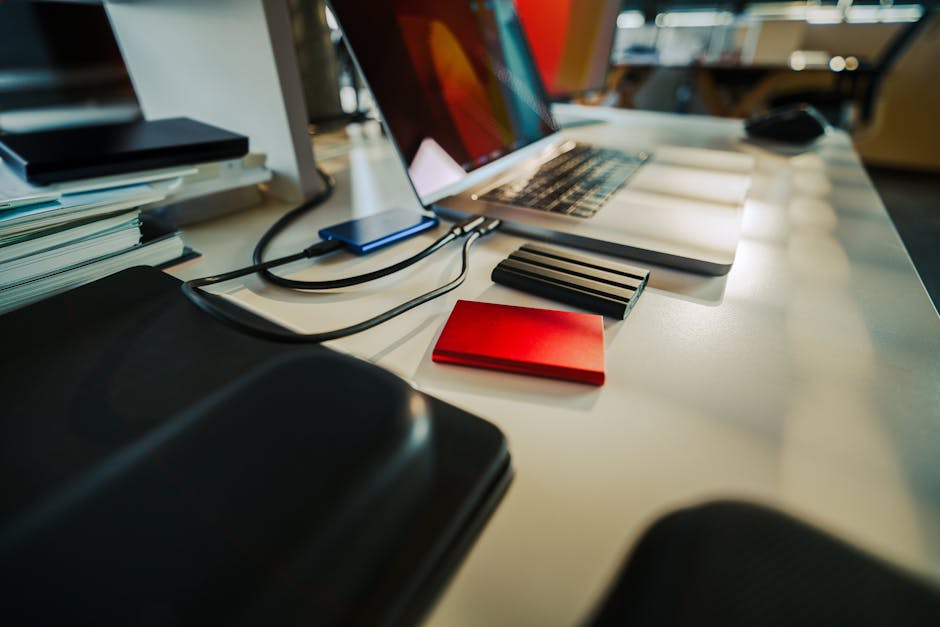 Hand connecting an external HDD drive with visible backup files on a computer screen