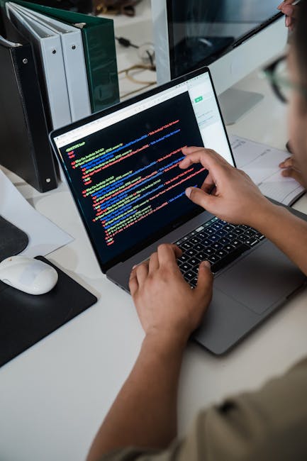Person working on a coding laptop with battery percentage visible, emphasizing real battery life