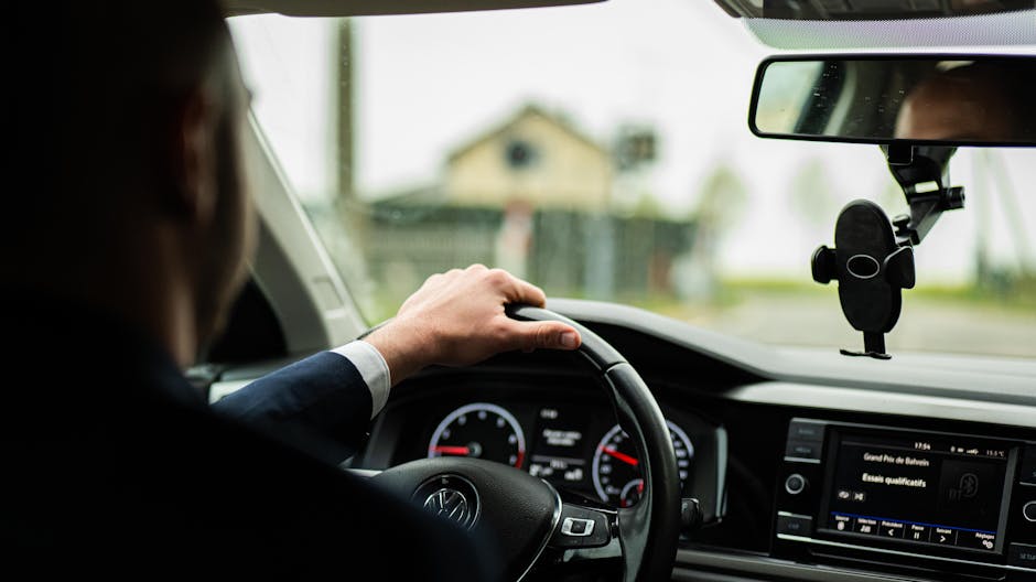 Driver using hands-free controls while audio plays from car speakers on a road trip