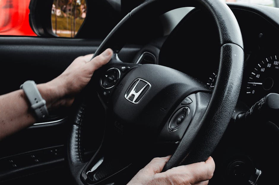 Driver controlling car media with steering wheel buttons while keeping eyes on the road