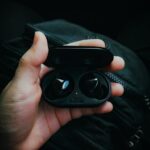 Gadget Review: Latest wireless earbuds on a desk, showing mic quality, latency, and battery life testing.