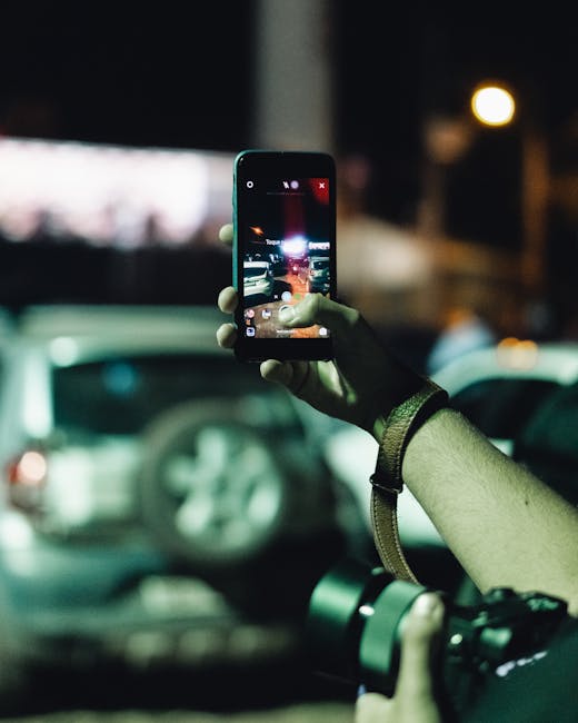 Person taking a night photo of a street sign with steady handheld framing