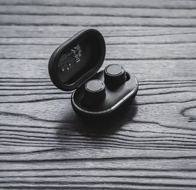 Wireless earbuds resting in a charging case on a desk while tracking battery life